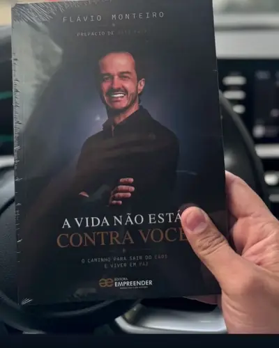 O livro ainda lacrado, na mão de um leitor, ao volante