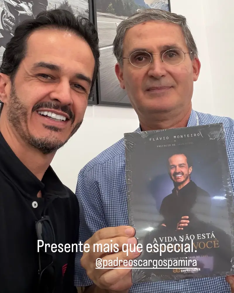 Padre Oscar segura o livro ao lado de Flávio