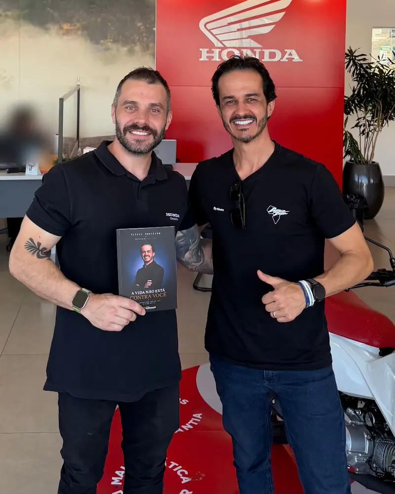 Ivan segura o livro ao lado de Flávio